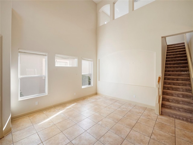 tiled spare room with a high ceiling