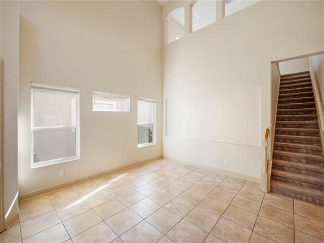 8320 Via Bella Notte, Orlando, FL 32836 - spare room featuring a high ceiling, light tile patterned flooring, and stairs
