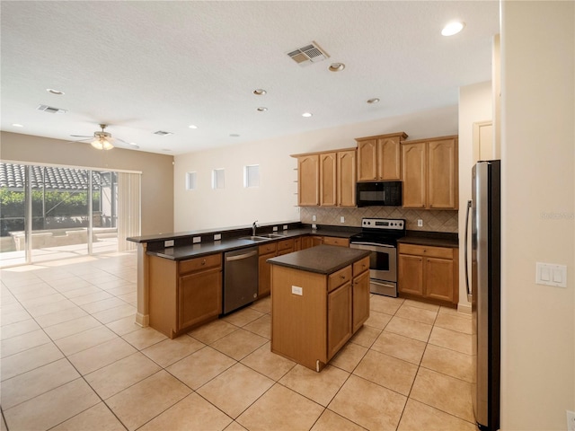 kitchen featuring light tile patterned flooring, sink, ceiling fan, a kitchen island, and stainless steel appliances