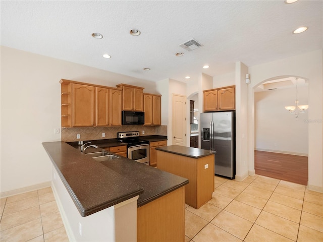 kitchen featuring sink, light tile patterned floors, kitchen peninsula, a kitchen island, and appliances with stainless steel finishes