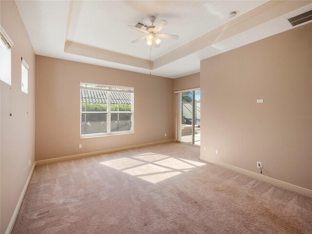 carpeted empty room featuring a tray ceiling and ceiling fan