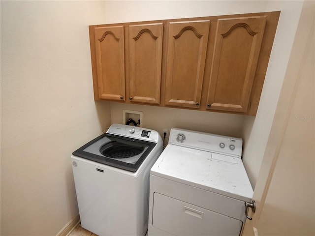 washroom featuring washing machine and clothes dryer and cabinets