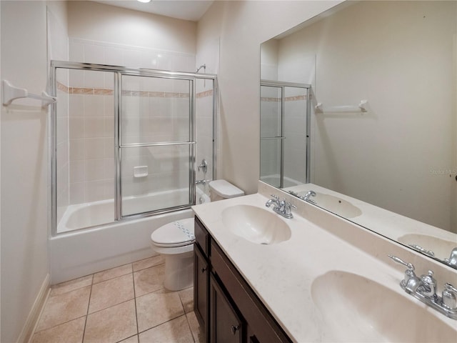 full bathroom featuring tile patterned floors, vanity, toilet, and bath / shower combo with glass door