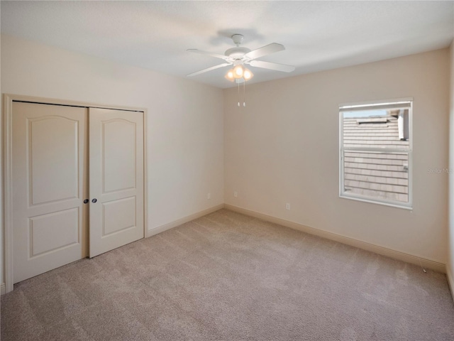 unfurnished bedroom with ceiling fan, a closet, and light colored carpet