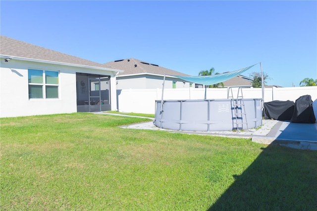 view of yard featuring a sunroom and a fenced in pool