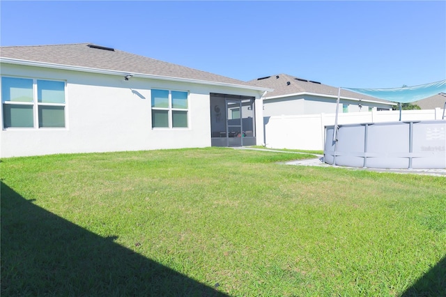 back of house with a lawn and a sunroom