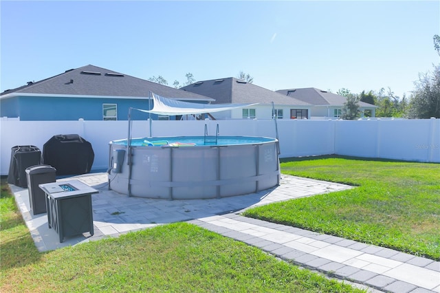 view of yard featuring a fenced in pool, a fire pit, and a patio area