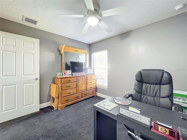 office area with ceiling fan, dark carpet, and a textured ceiling