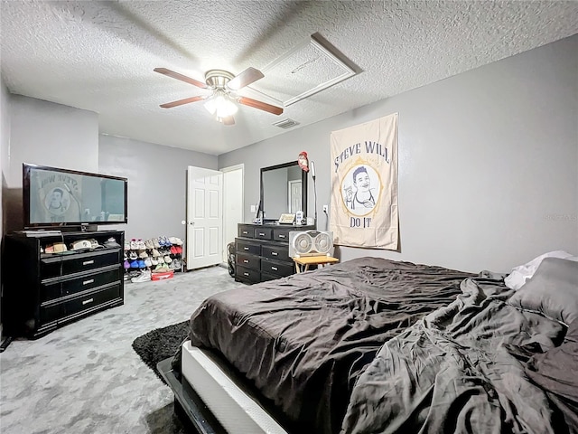 carpeted bedroom featuring ceiling fan and a textured ceiling