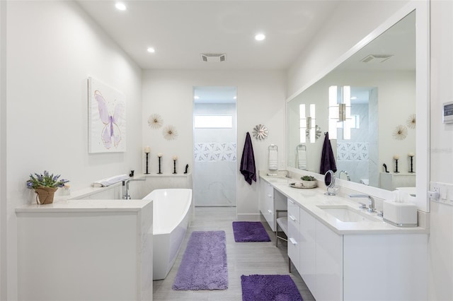 bathroom featuring hardwood / wood-style floors, vanity, and independent shower and bath