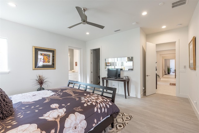 bedroom featuring ceiling fan, light hardwood / wood-style floors, and connected bathroom