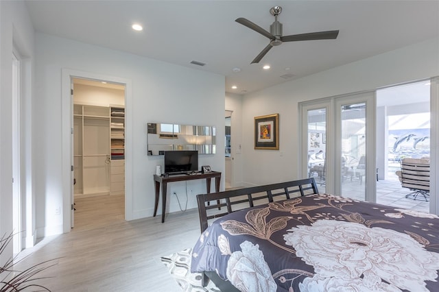 bedroom with ceiling fan, access to exterior, a spacious closet, light hardwood / wood-style floors, and a closet