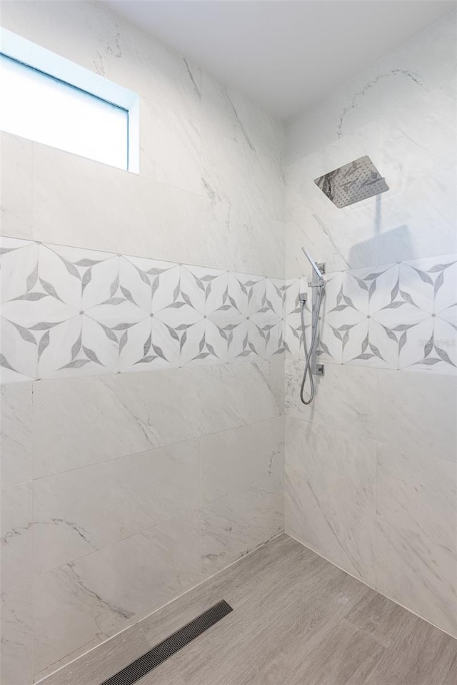 bathroom featuring a tile shower and hardwood / wood-style flooring