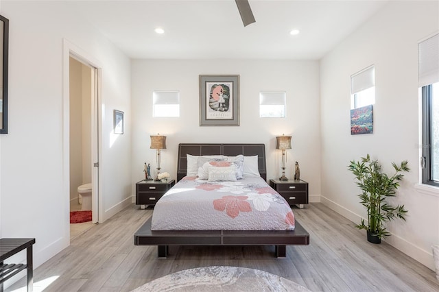 bedroom featuring connected bathroom, light hardwood / wood-style flooring, and ceiling fan