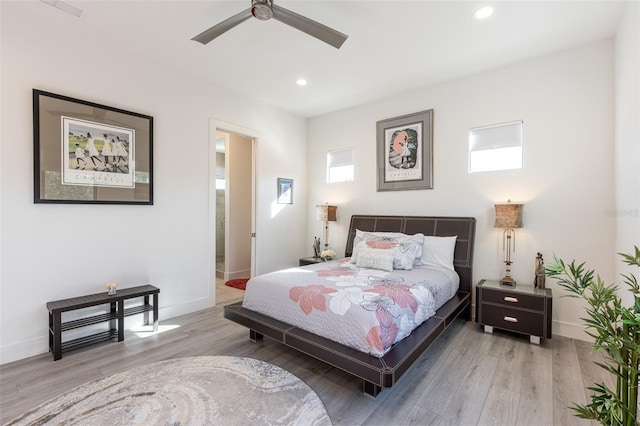 bedroom featuring ceiling fan, ensuite bathroom, and light hardwood / wood-style floors