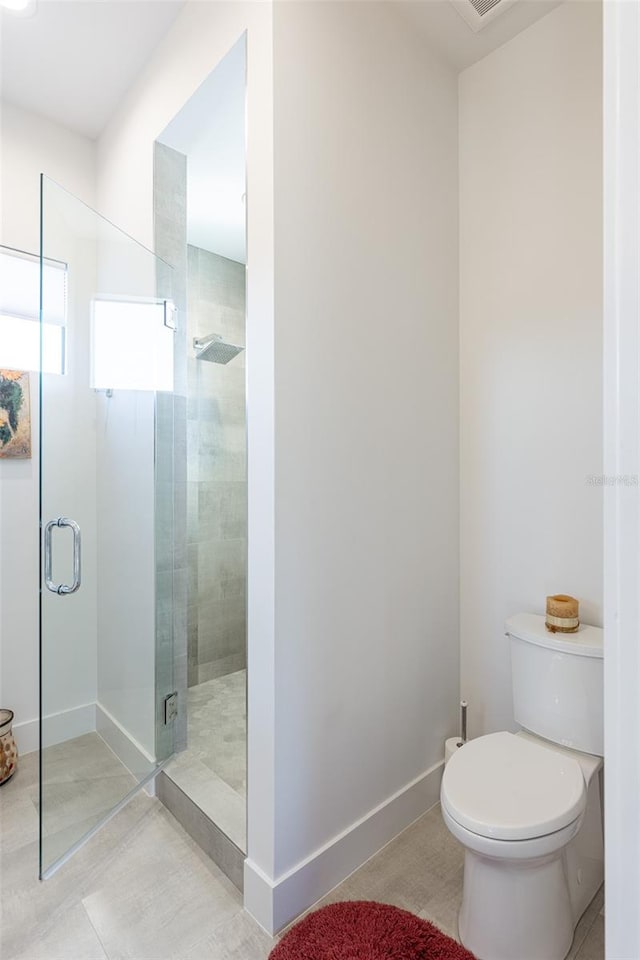 bathroom with toilet, tile patterned flooring, and walk in shower