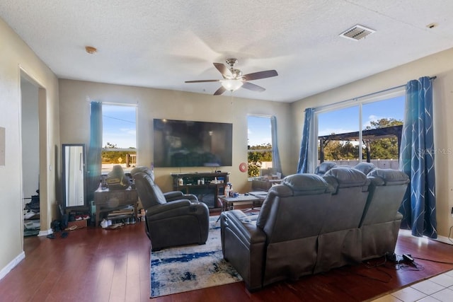 living room featuring hardwood / wood-style floors, a textured ceiling, and ceiling fan