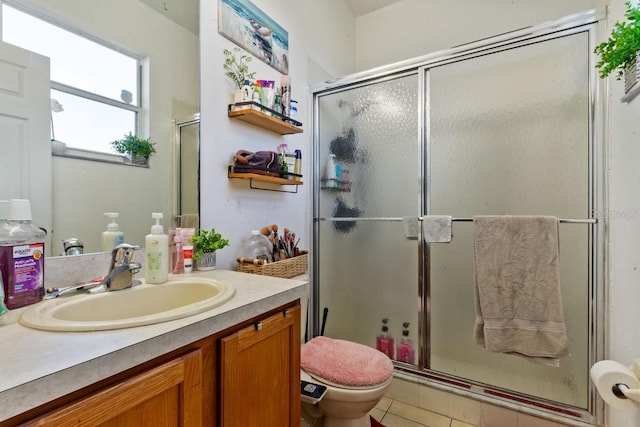 bathroom with toilet, vanity, tile patterned floors, and walk in shower