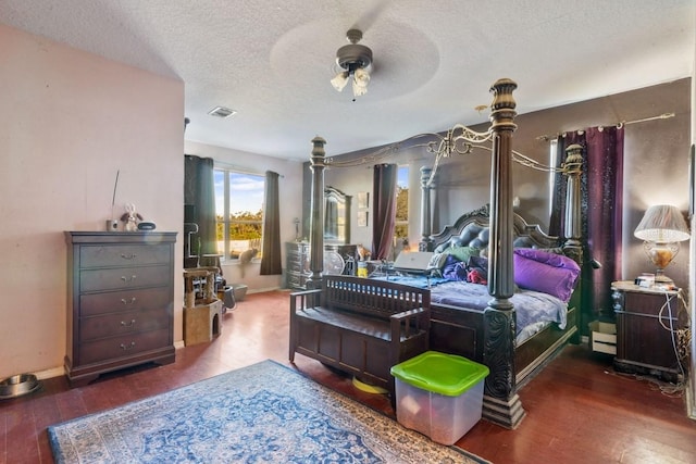 bedroom with dark hardwood / wood-style floors, ceiling fan, and a textured ceiling