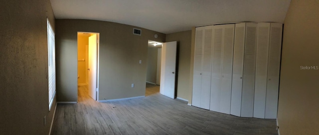 unfurnished bedroom featuring a closet and hardwood / wood-style flooring