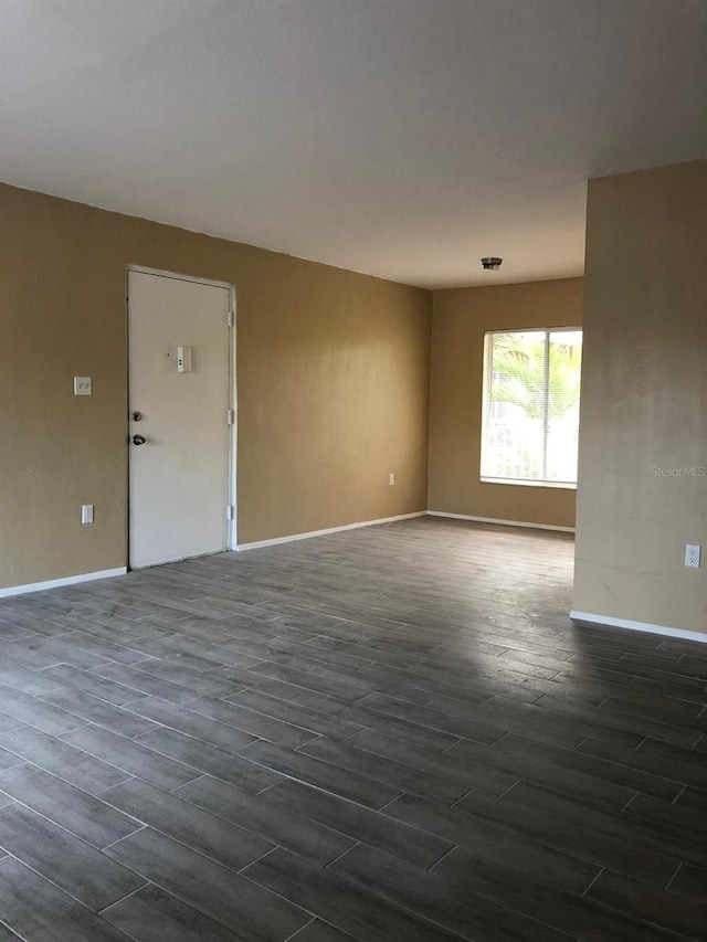 unfurnished room with dark hardwood / wood-style floors