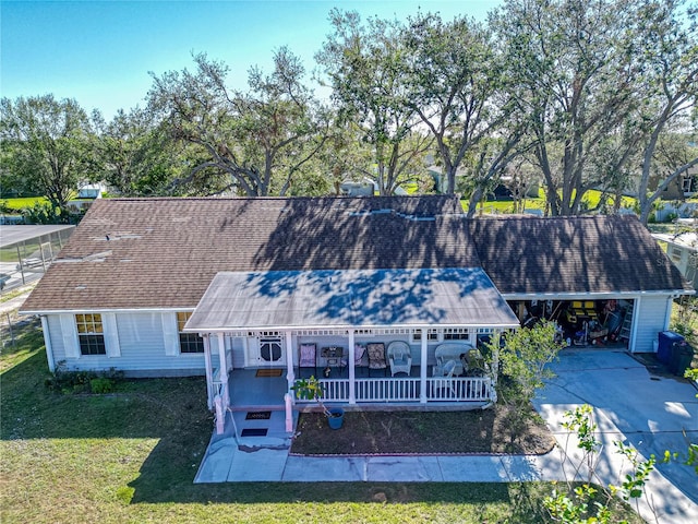 exterior space with a garage, covered porch, and a front lawn