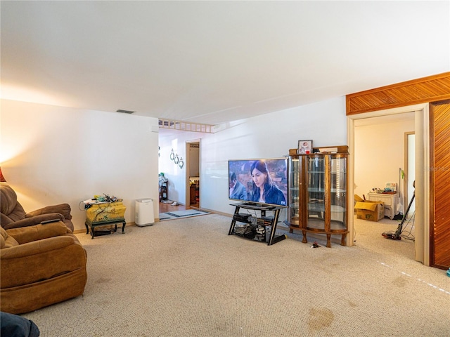 carpeted living room with wooden walls