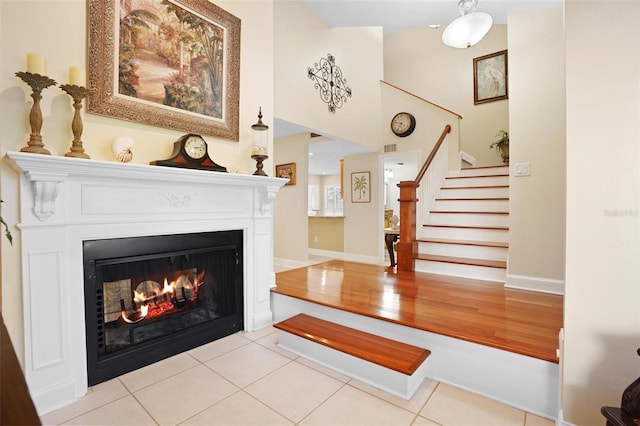 300 Spring Run Cir, Longwood, FL 32779 - living area featuring a lit fireplace, stairs, baseboards, and tile patterned flooring