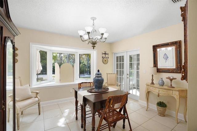 tiled dining space with french doors, a textured ceiling, and an inviting chandelier