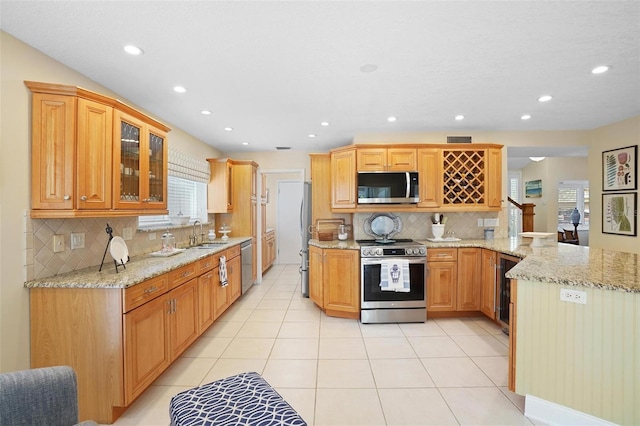 300 Spring Run Cir, Longwood, FL 32779 - kitchen with appliances with stainless steel finishes, plenty of natural light, a peninsula, decorative backsplash, and recessed lighting