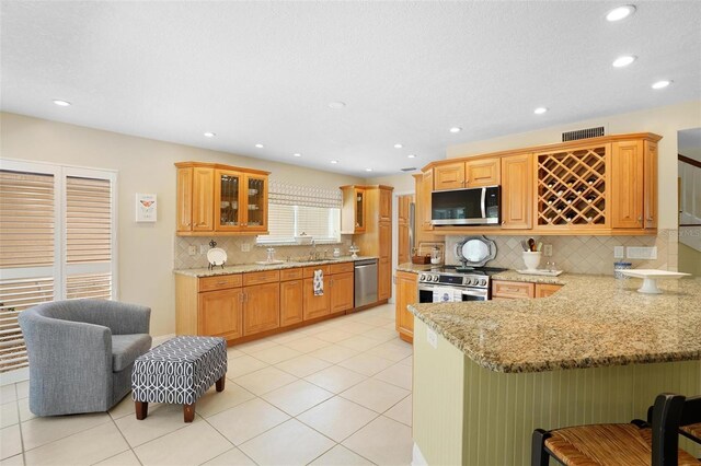 300 Spring Run Cir, Longwood, FL 32779 - kitchen with appliances with stainless steel finishes, a sink, a peninsula, a breakfast bar, and backsplash
