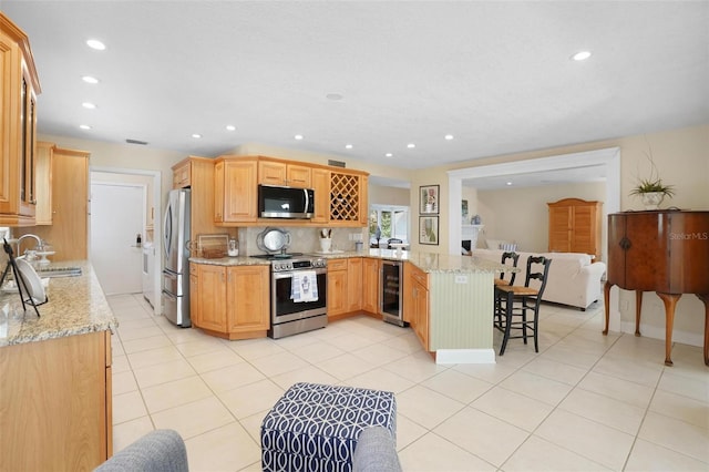 300 Spring Run Cir, Longwood, FL 32779 - kitchen with appliances with stainless steel finishes, a sink, a peninsula, beverage cooler, and a breakfast bar