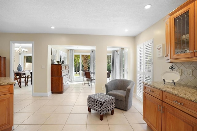 interior space with a chandelier, light tile patterned floors, and a textured ceiling