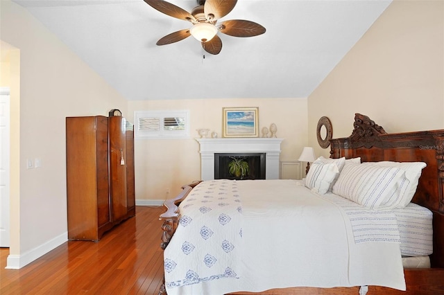 bedroom with hardwood / wood-style floors, ceiling fan, and lofted ceiling