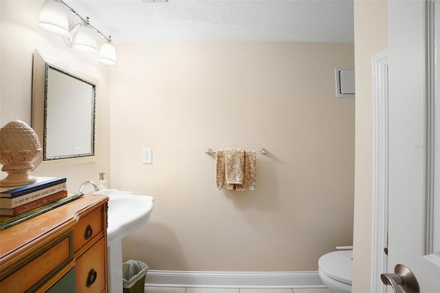 bathroom featuring tile patterned floors, toilet, and a textured ceiling