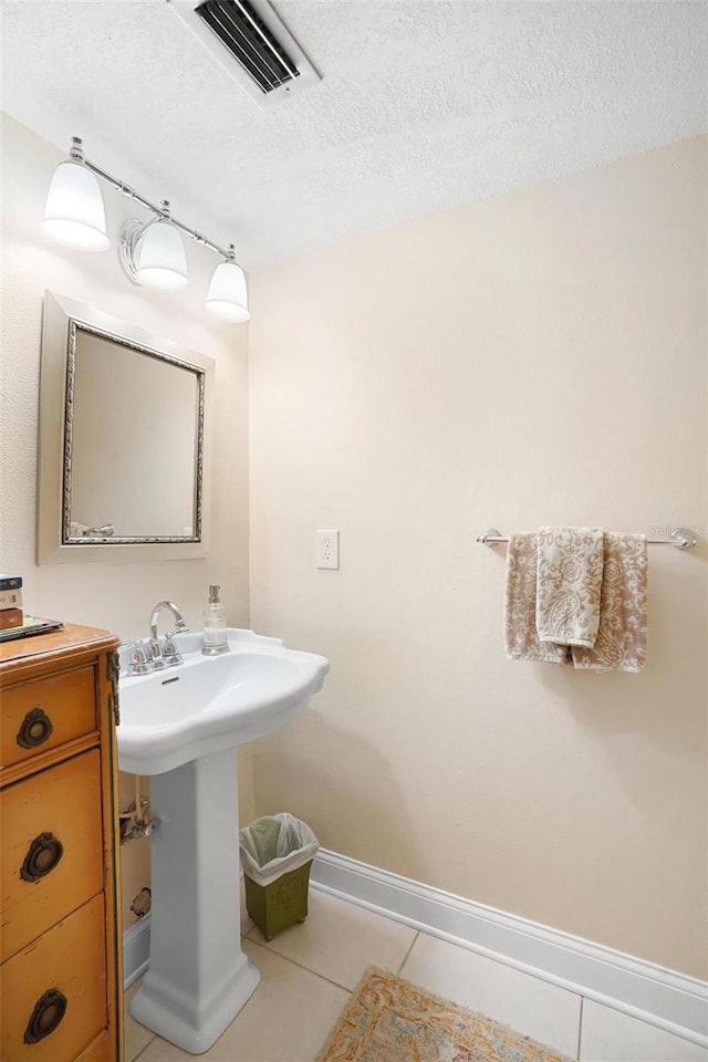 bathroom featuring tile patterned floors and a textured ceiling