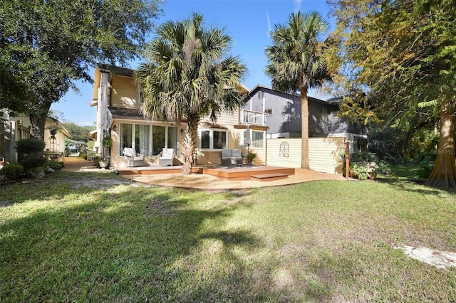 back of property with a patio area, a balcony, a yard, and a wooden deck