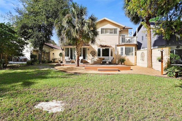 rear view of house with a lawn, a wooden deck, a balcony, and an outdoor hangout area