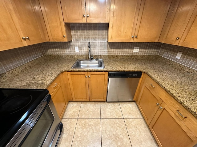 kitchen featuring backsplash, light stone counters, sink, and stainless steel dishwasher