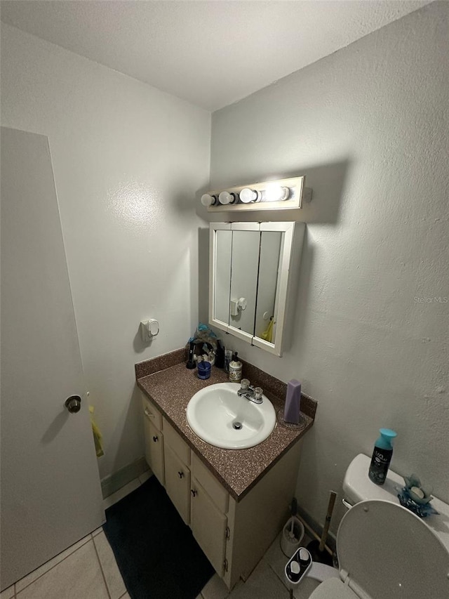 bathroom with tile patterned floors, vanity, and toilet