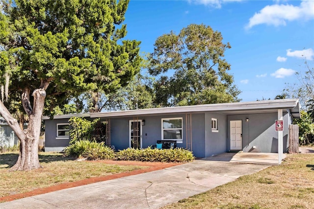 single story home featuring a front lawn and a carport