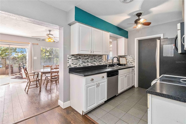 kitchen featuring backsplash, white cabinets, sink, stainless steel dishwasher, and light hardwood / wood-style floors