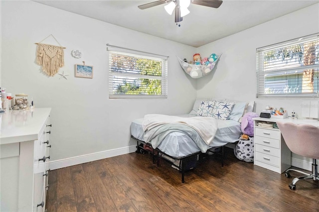 bedroom featuring multiple windows, dark wood-type flooring, and ceiling fan