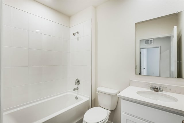 full bathroom featuring vanity, tiled shower / bath combo, and toilet