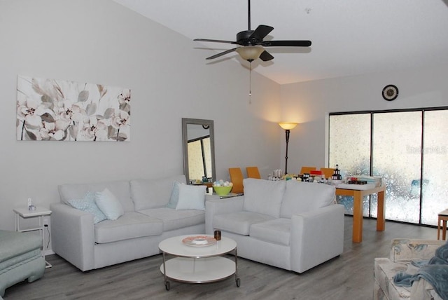 living room with hardwood / wood-style flooring, ceiling fan, and high vaulted ceiling