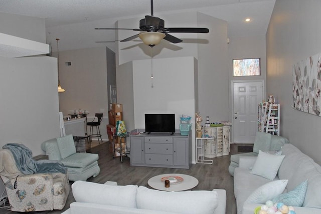 living room featuring ceiling fan, dark wood-type flooring, and vaulted ceiling