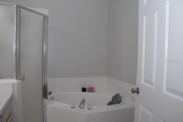 bathroom featuring plus walk in shower and vanity