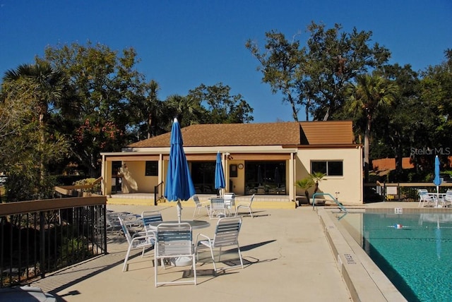 rear view of house with a community pool and a patio