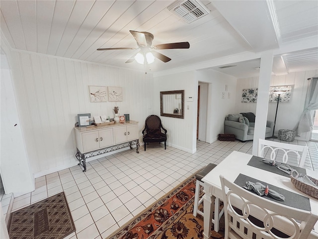 living room with ceiling fan, wooden walls, light tile patterned floors, and wood ceiling