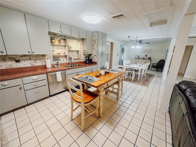 kitchen with tasteful backsplash, dishwasher, light tile patterned flooring, and sink